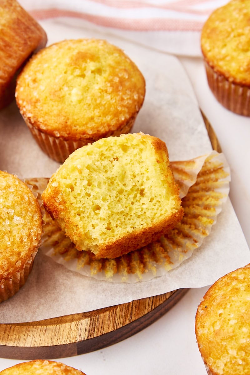 half of an orange ricotta muffin surrounded by more muffins