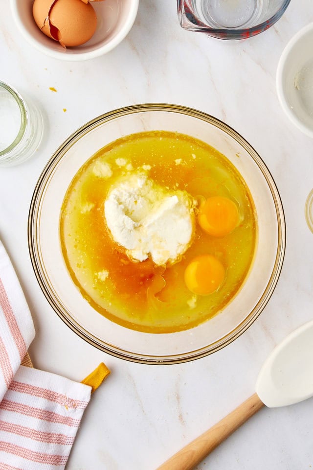 overhead view of wet ingredients for orange ricotta muffins in a glass mixing bowl