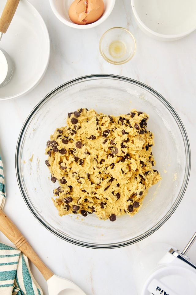 overhead view of tahini chocolate chip cookie dough in a glass mixing bowl