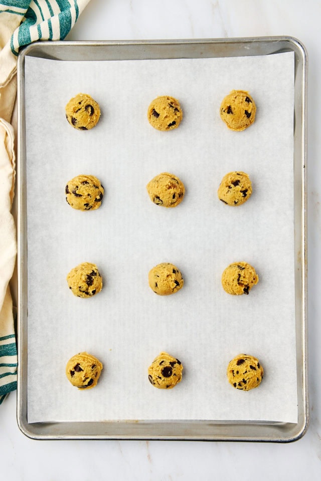 overhead view of scooped tahini chocolate chip cookie dough on a baking sheet ready to go into the oven