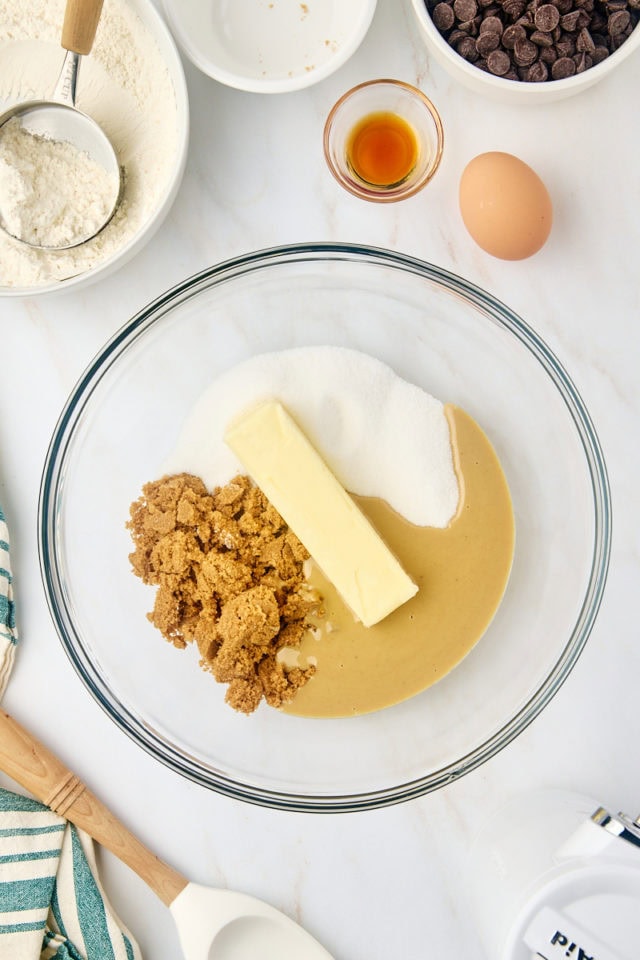 overhead view of butter, tahini, sugar, and brown sugar in a glass mixing bowl