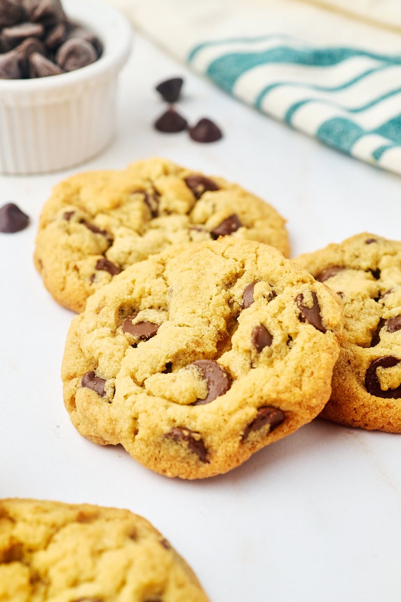 three tahini chocolate chip cookies on a marble countertop