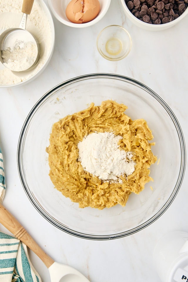 overhead view of dry ingredients added to wet ingredients for tahini chocolate chip cookies