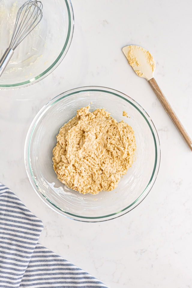 overhead view of baked doughnuts batter in a glass mixing bowl