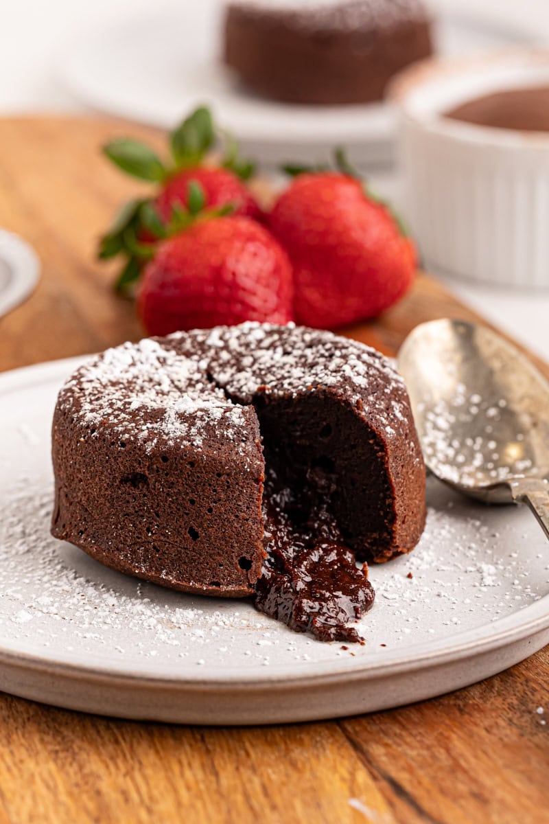 a chocolate lava cake on a white plate with the center spilling out