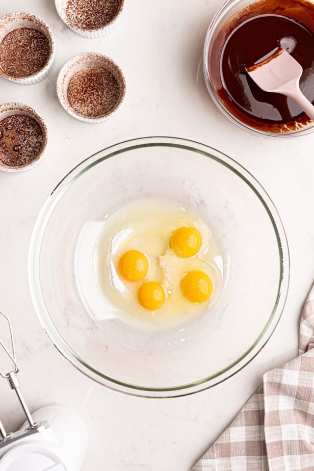 overhead view of eggs, sugar, and salt in a glass mixing bowl