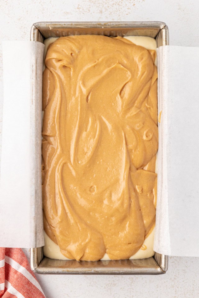 overhead view of cookie butter batter on top of vanilla batter in a loaf pan