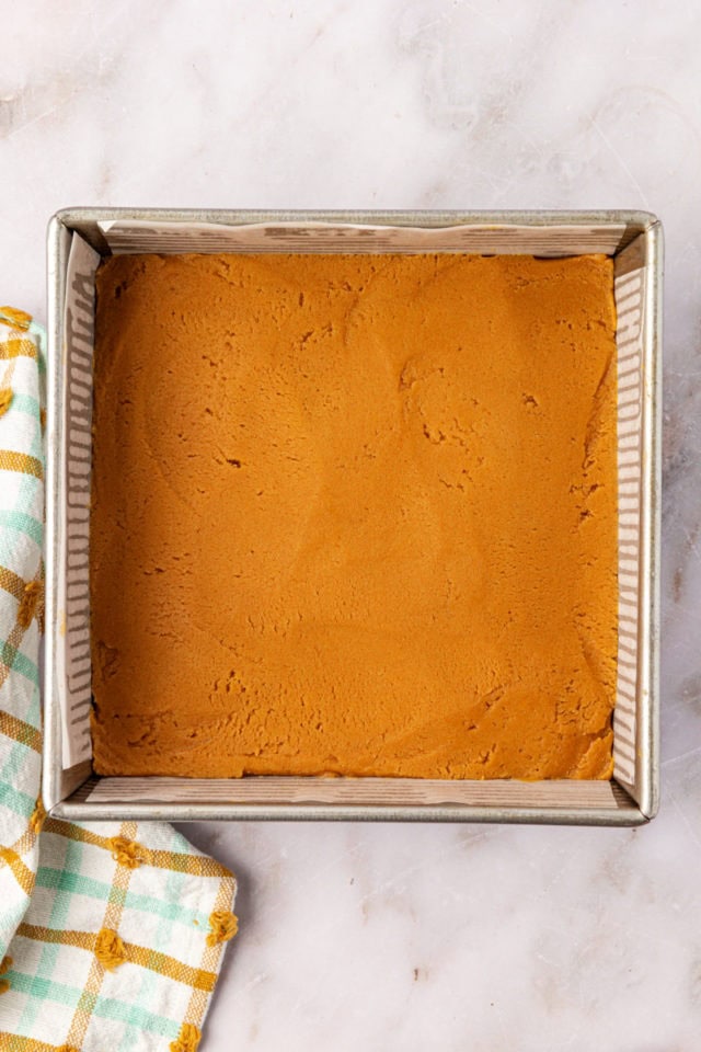 overhead view of peanut butter cookie dough spread in a square baking pan