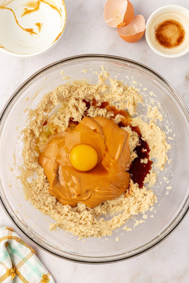 overhead view of peanut butter, eggs, and vanilla extract added to creamed butter and sugar