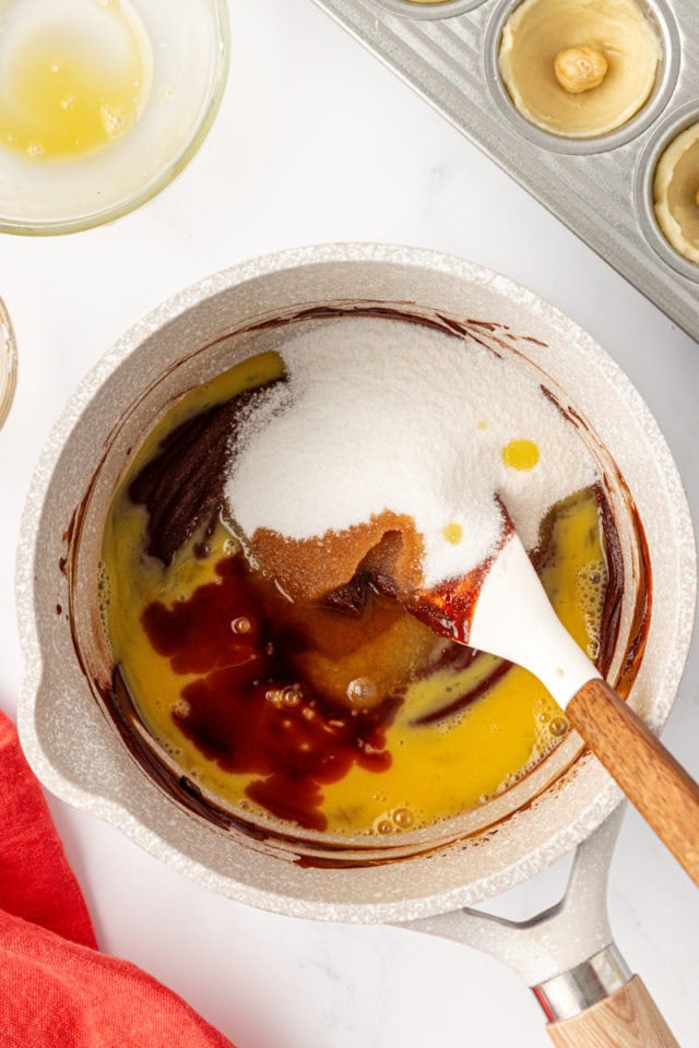 overhead view of sugar, egg, vanilla, and salt added to melted chocolate and butter