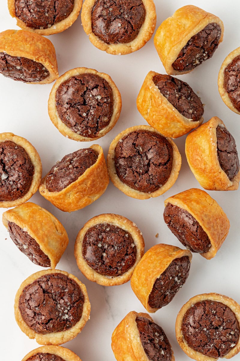 overhead view of brownie tassies scattered on a white surface