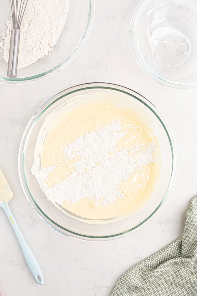 overhead view of dry ingredients added to wet ingredients for tres leches cake batter