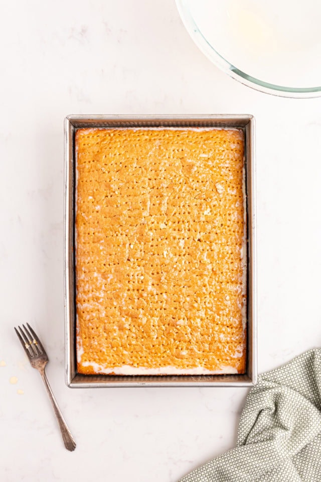 overhead view of tres leches cake with the milk mixture poured over and soaking into the cake