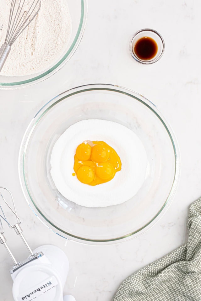 overhead view of egg yolks and sugar in a mixing bowl