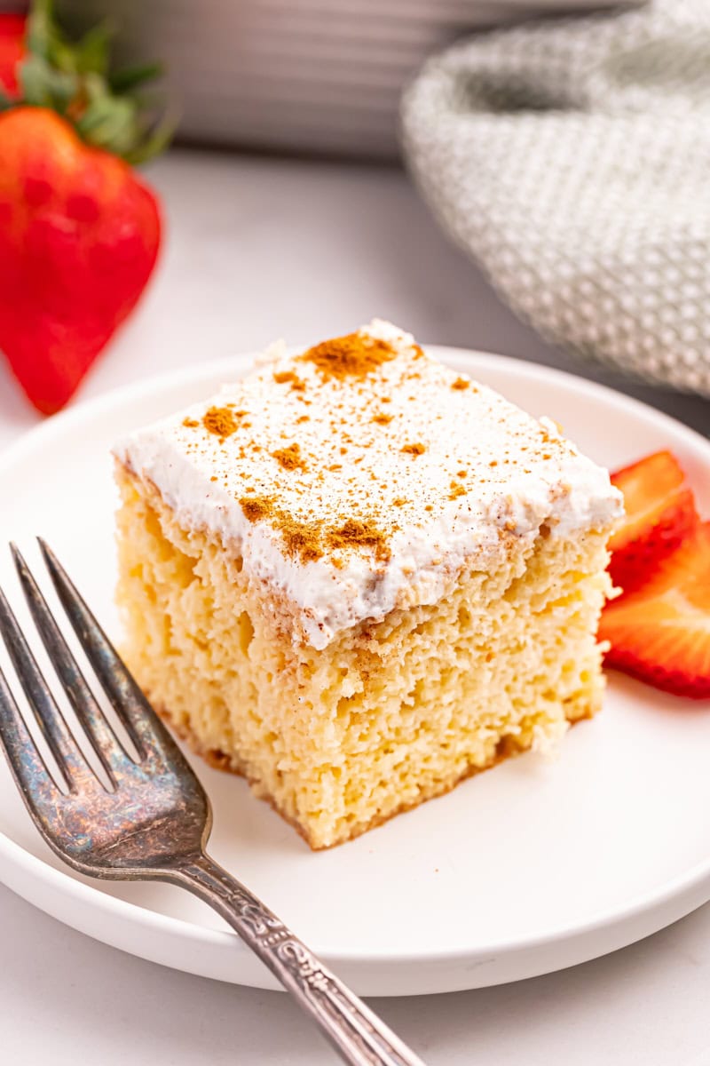 a slice of tres leches cake on a white plate