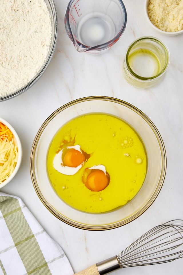 overhead view of olive oil, milk, and eggs in a mixing bowl