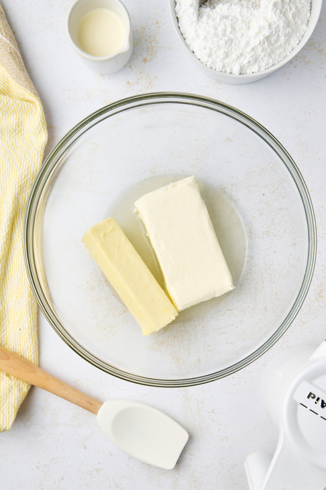 overhead view of cream cheese, butter, salt, and lemon juice in a mixing bowl