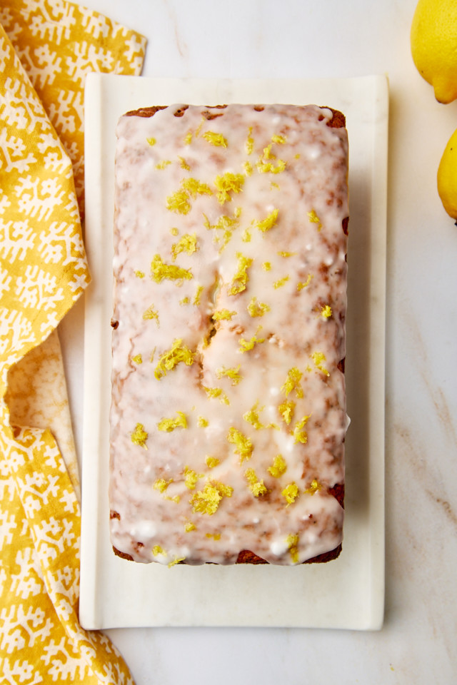 overhead view of glazed lemon poppy seed loaf on a white tray