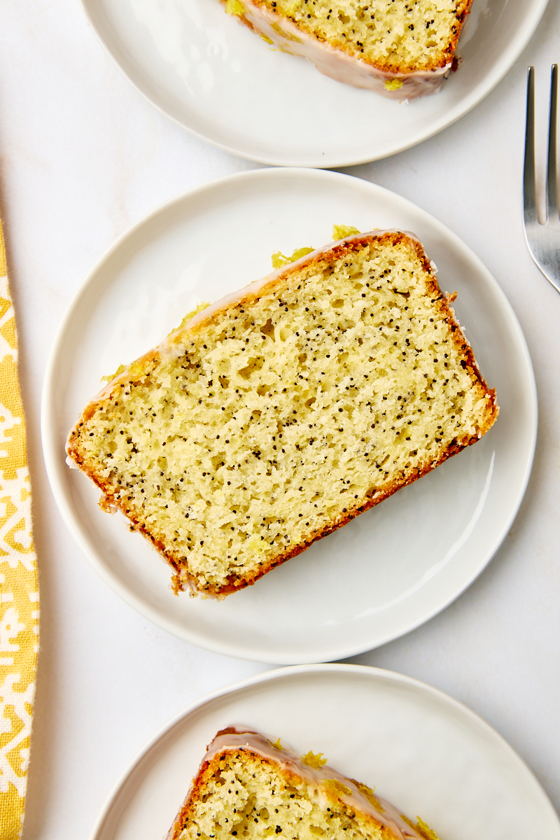 overhead view of a slice of lemon poppy seed loaf on a white plate