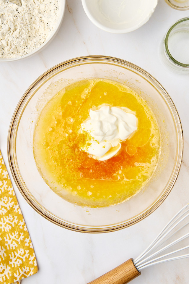 overhead view of sour cream, vegetable oil, lemon juice, lemon zest, and vanilla extract added to sugar/egg mixture