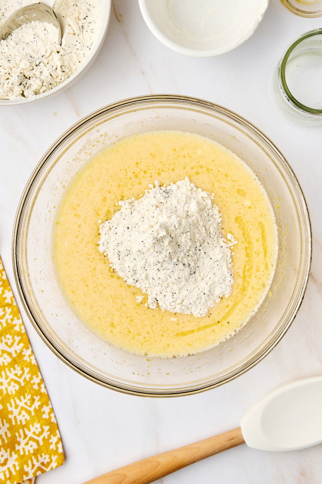 overhead view of dry ingredients added to wet ingredients for lemon poppy seed loaf