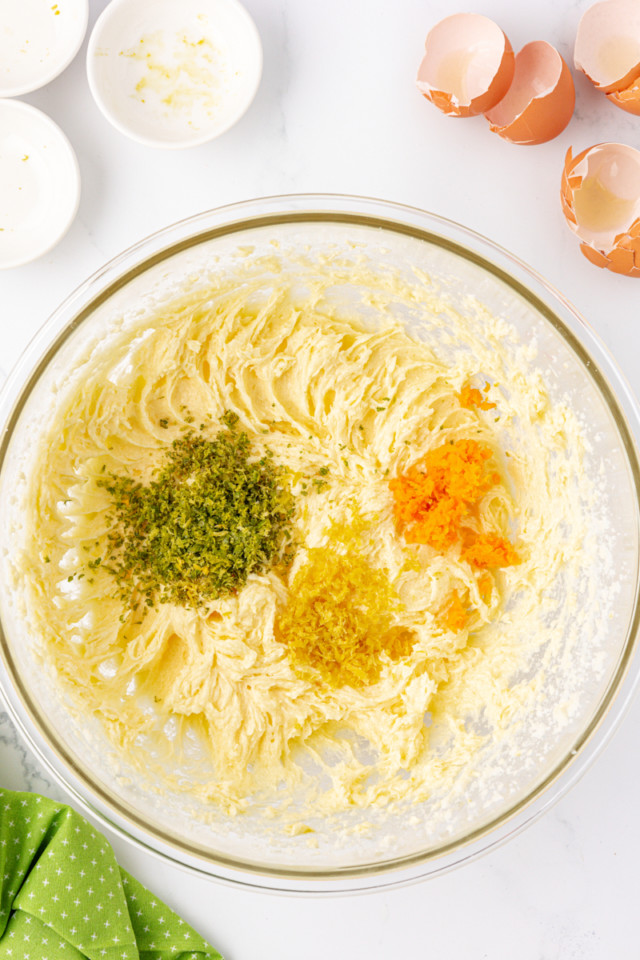 overhead view of lime, lemon, and orange zest added to creamed butter and sugar