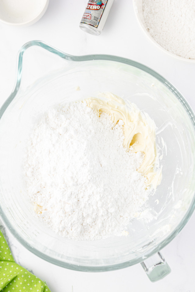 overhead view of confectioners' sugar added to tequila-lime frosting