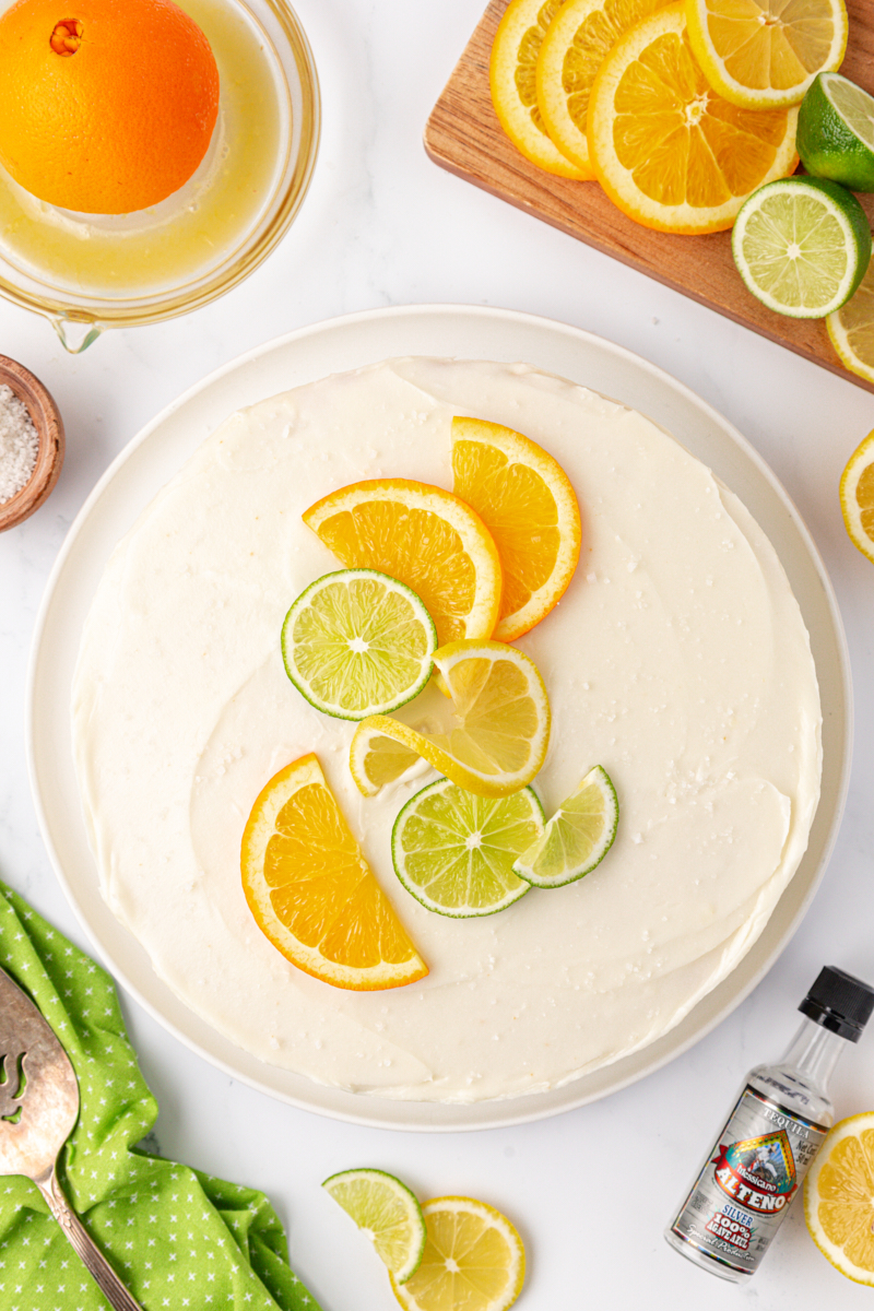 overhead view of citrus cake with tequila lime frosting on a white cake plate