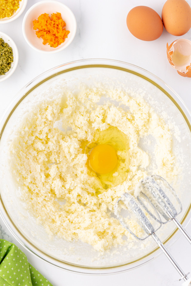 overhead view of egg added to creamed butter and sugar