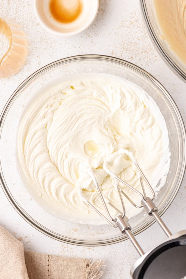 overhead view of whipped cream in a glass mixing bowl