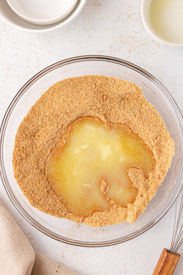 overhead view of melted butter added to a mixture of graham cracker crumbs and sugar