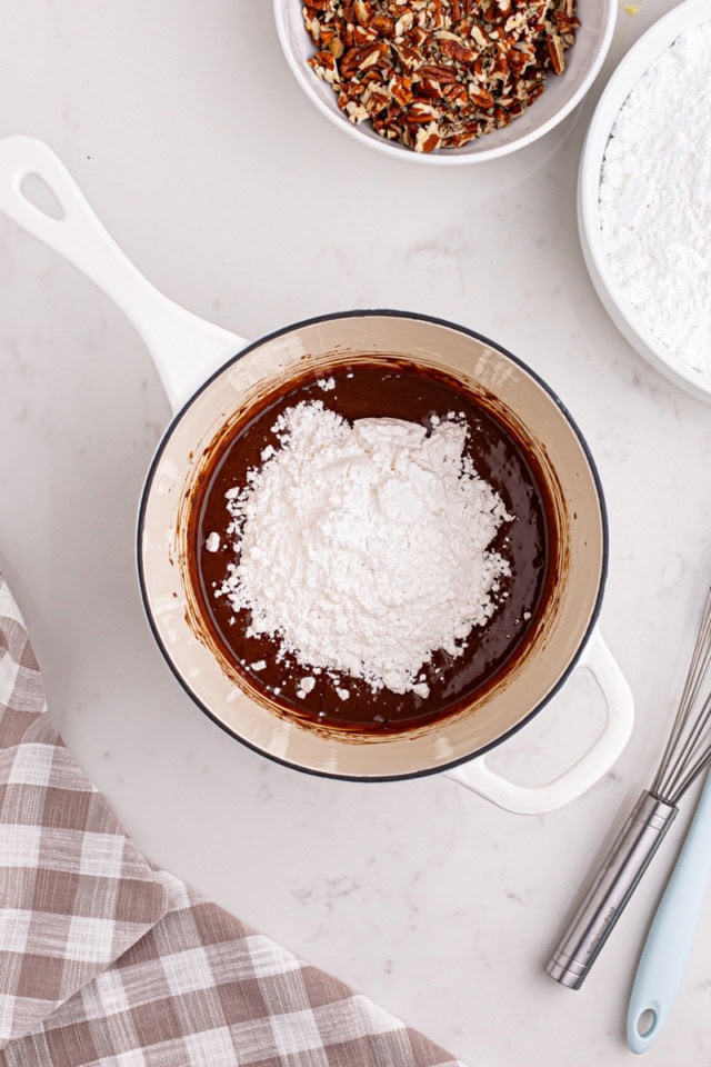 overhead view of confectioners' sugar and vanilla added to frosting mixture