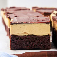 buckeye brownies on parchment paper on top of a wooden cutting board