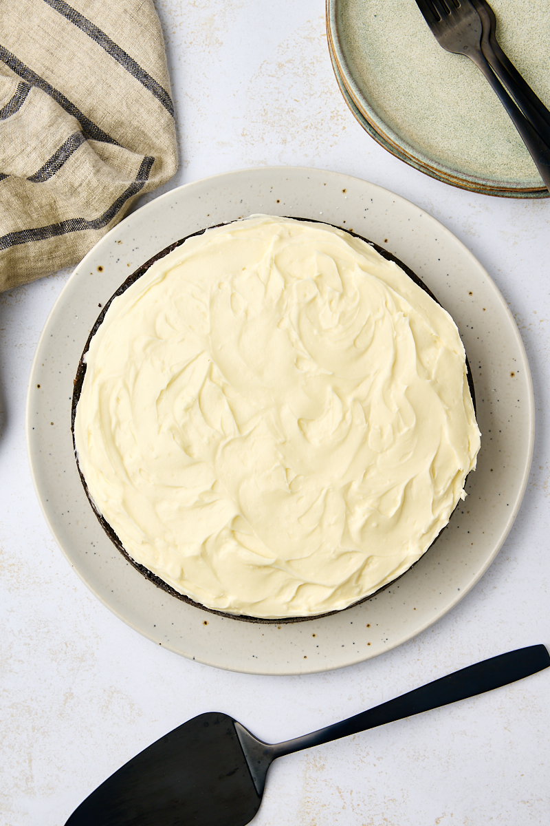 overhead view of frosted Guinness chocolate cake on a beige speckled cake plate