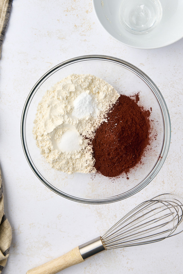 overhead view of flour, cocoa powder, baking soda, and salt in a glass mixing bowl