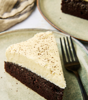 a slice of Guinness chocolate cake on a green plate with another slice in the background