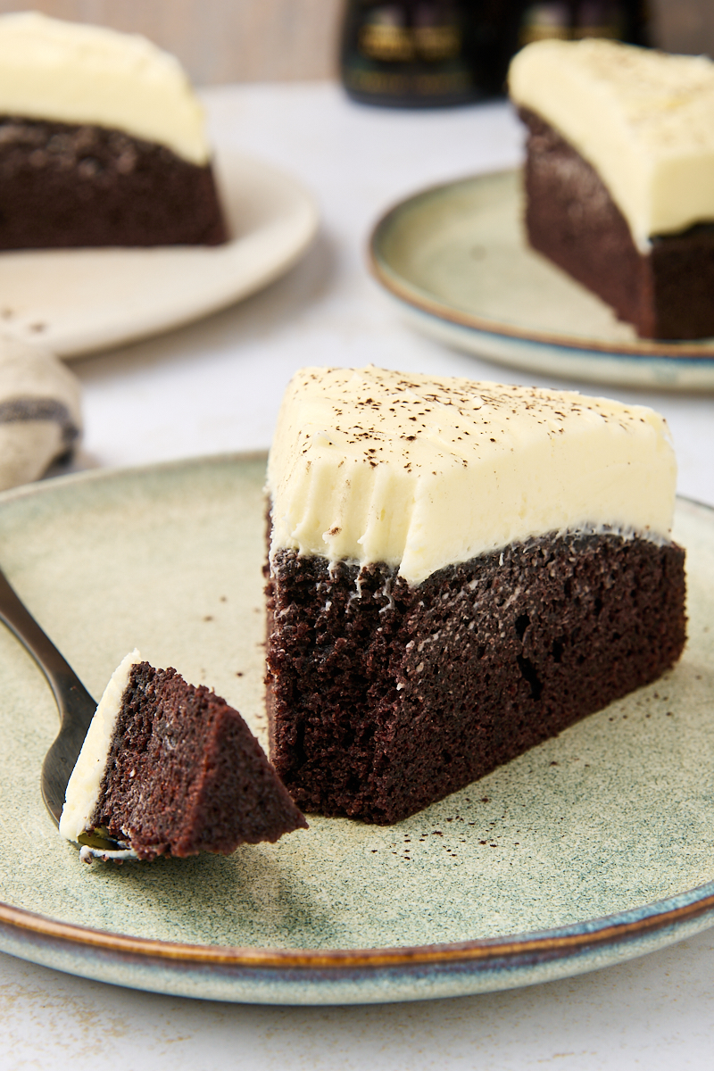 a slice of Guinness chocolate cake on a plate with a bite on a fork