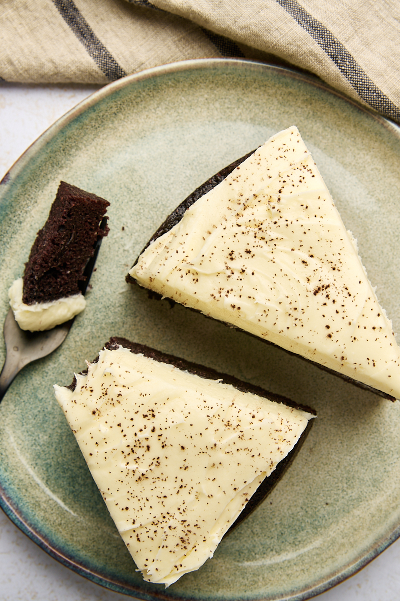 overhead view of two slices of Guinness chocolate cake on a green plate with a bite on a fork