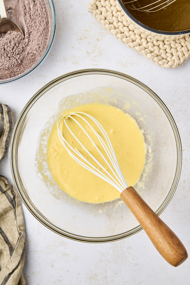 overhead view of combined eggs, sour cream and vanilla in a glass mixing bowl