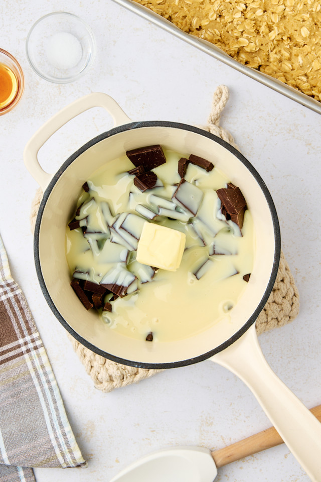 overhead view of sweetened condensed milk, chocolate, and butter in a saucepan