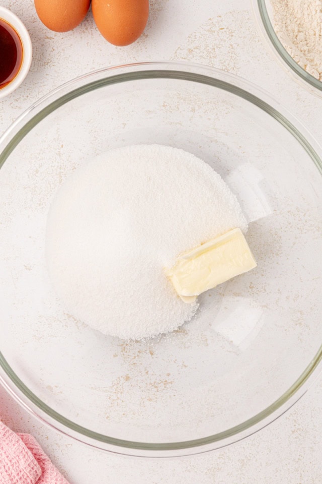 overhead view of butter and sugar in a glass mixing bowl