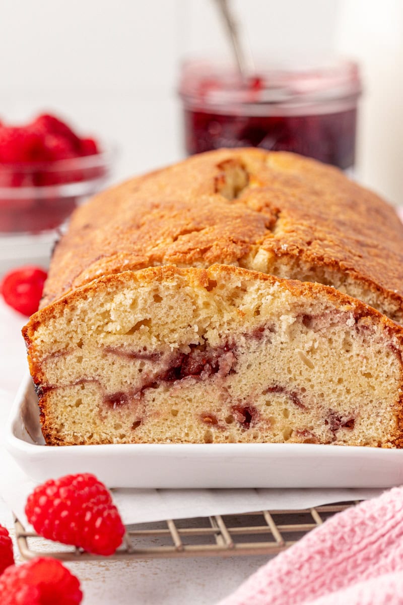 partially sliced berry swirl pound cake on a white tray