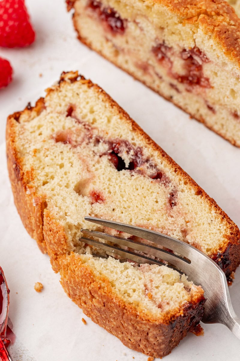 a fork cutting into a slice of berry swirl pound cake