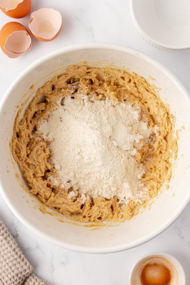 overhead view of dry ingredients added to wet ingredients for cookie dough