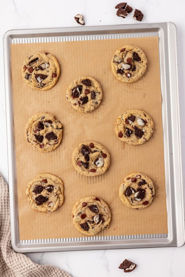 overhead view of freshly baked Oreo chocolate chip cookies on a parchment-lined baking sheet
