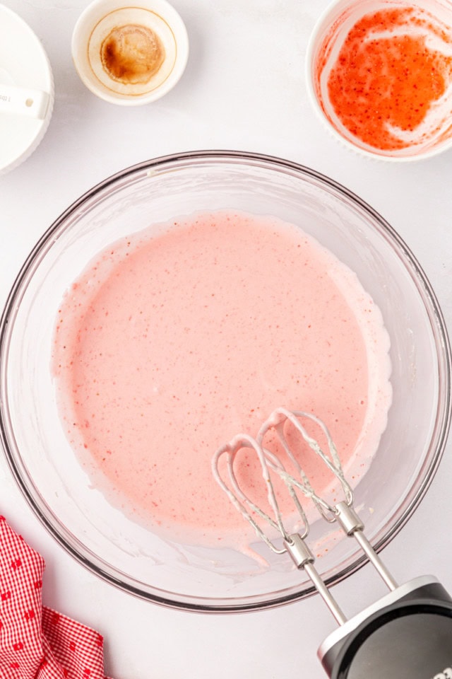 overhead view of strawberry no-bake cheesecake filling in a glass mixing bowl