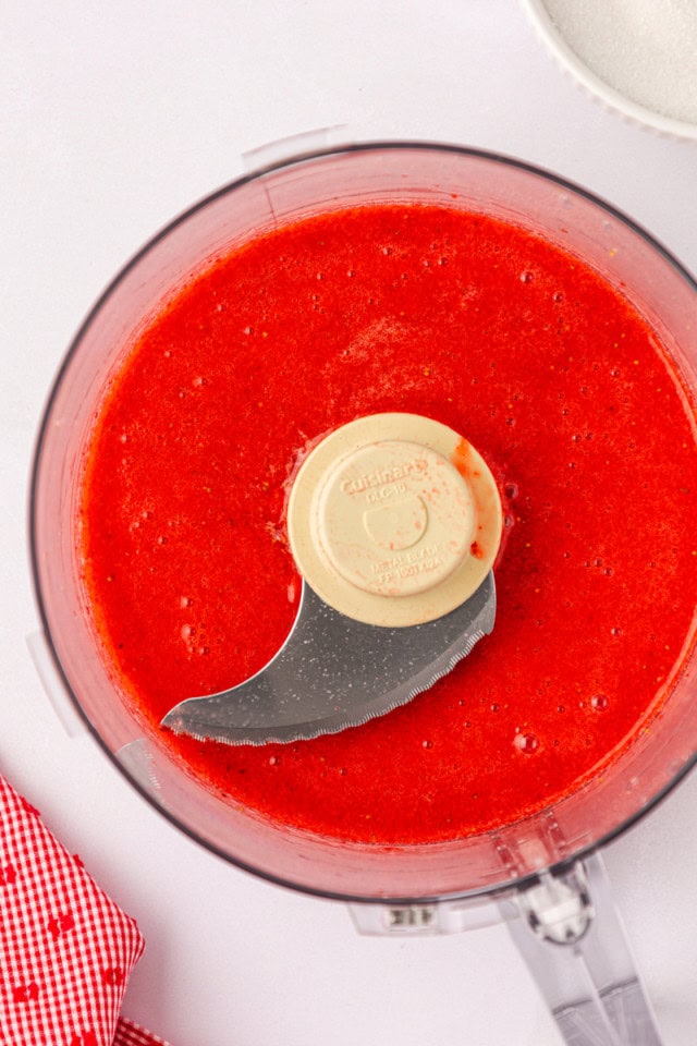 overhead view of pureed strawberries in the bowl of a food processor