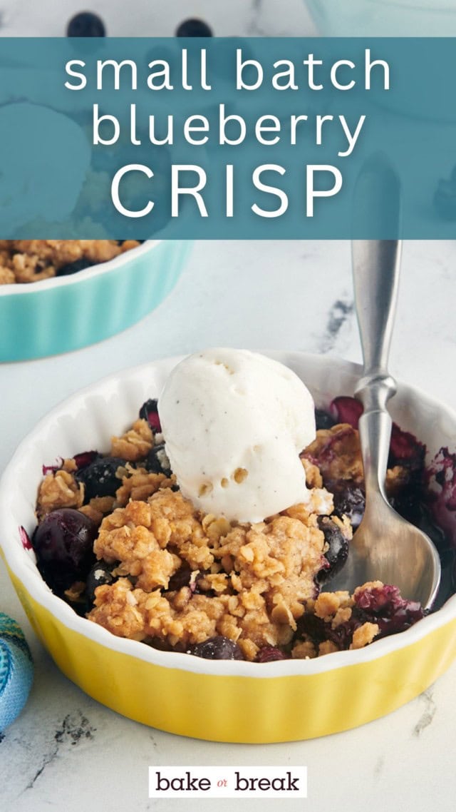 a serving of blueberry crisp for two in a yellow dessert bowl with a spoon resting in the bowl; text overlay "small batch blueberry crisp"