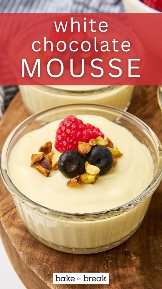 white chocolate mousse served in a small glass ramekin and topped with fresh berries and chopped pistachios