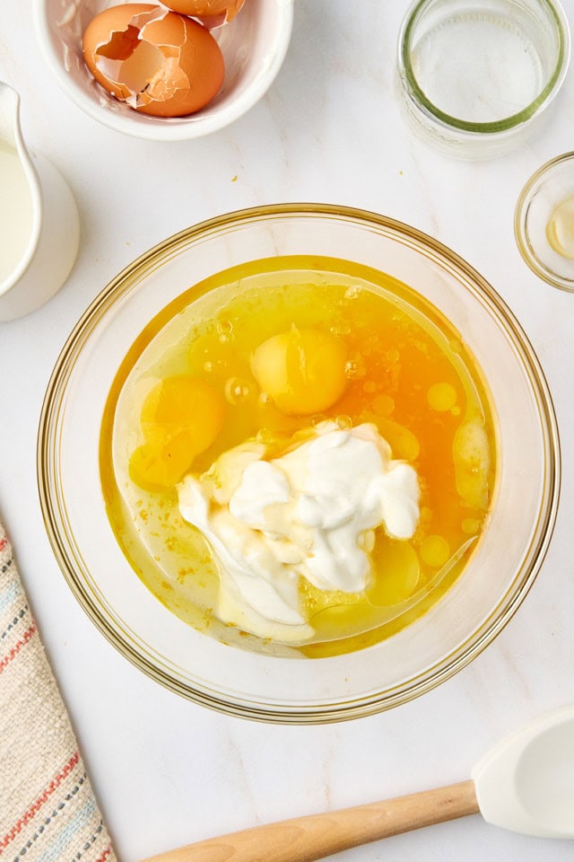 overhead view of wet ingredients for yogurt cake in a glass mixing bowl